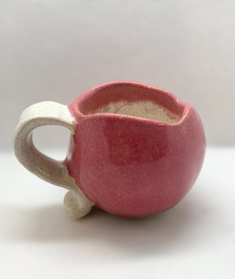 Taza esférica rosada exterior, interior y asa blanco con puntos. Borde irregular